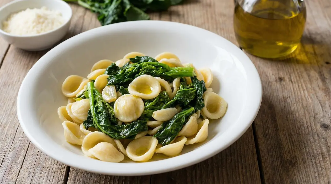 Piatto di orecchiette con cime di rapa, olio extravergine e aglio su tavolo rustico